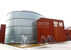 a building with water fountains in front of it and chinese writing on the side of the building