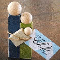 a small gift box with two wooden balls on top and a tag attached to it