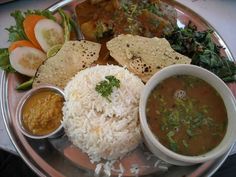 a plate with rice, beans and tortillas on it