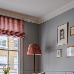 a living room filled with furniture and pictures on the wall next to a large window