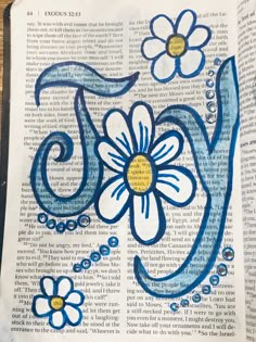 an open book with blue and white flowers on it