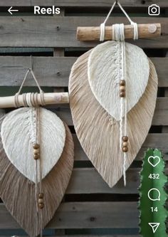 two wall hangings made out of rafters and wood planks, one with tassels on it