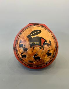 an orange and black painted object with animals on it