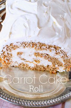 a carrot cake with white frosting on a silver platter next to a fork