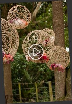 some kind of decoration hanging from the tree in front of trees with flowers on them