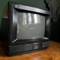 an old television sitting on top of a wooden table