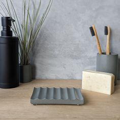 a soap dish, soap and toothbrush on a table