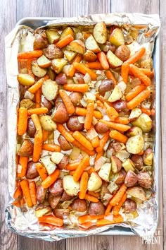 baked potatoes and carrots in a baking pan on a wooden table with text overlay