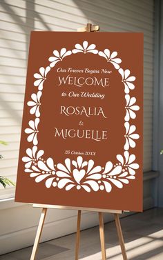 an easel with a sign on it that says, welcome to our wedding rosalia and miguel