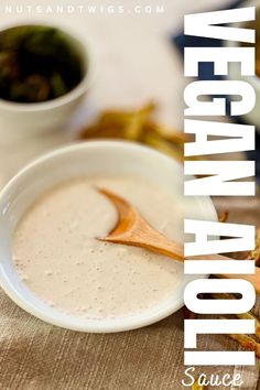 a white bowl filled with liquid sitting on top of a table next to other foods