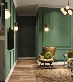 a living room with green walls and furniture in the center, along with wooden flooring