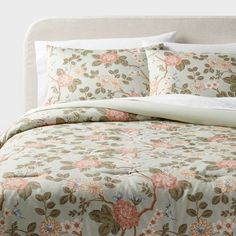 the comforter is made up and has pink flowers on it