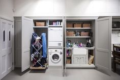 a washer and dryer in a small room with shelves on either side of the door