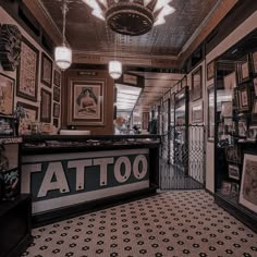 the inside of a tattoo shop with lots of pictures on the walls and flooring