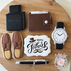 a wooden table topped with cookies and other items next to a watch, pen and wallet