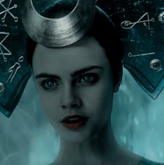 a woman with horns on her head and blue eyes is staring at something in the distance