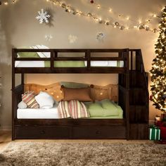 a bunk bed with christmas decorations and lights on the wall next to it is lit up