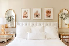 a bed with white sheets and pillows in a bedroom next to two mirrors on the wall