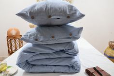 a stack of pillows sitting on top of each other in front of a table with food