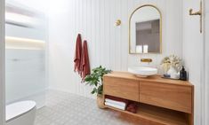 a bathroom with a sink, mirror and bathtub in the middle of the room