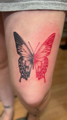 a woman's thigh with a butterfly and skull tattoo on the side of her leg