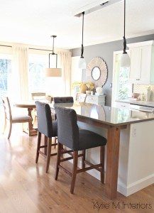 a kitchen island with four chairs and a table in front of the counter top area