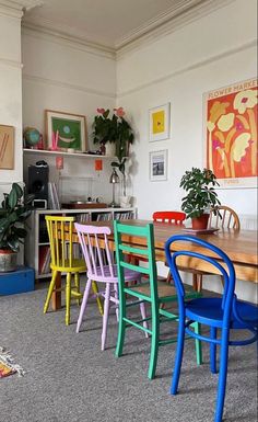 colorful chairs are lined up on the carpeted floor in a room with white walls