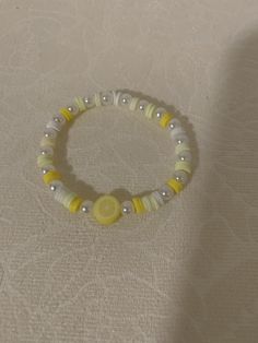 a yellow and white beaded bracelet sitting on top of a table