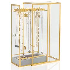 a gold jewelry box with several necklaces and earrings in it's display case