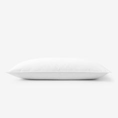 a white pillow sitting on top of a bed