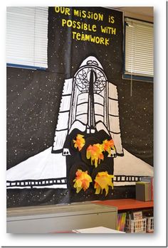 a bulletin board with flowers on it in front of a space shuttle and the words our mission is possible with teamwork