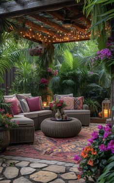 an outdoor living room with lots of plants and lights on the ceiling, surrounded by greenery