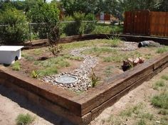 an empty garden with rocks and plants in the center, surrounded by fenced area