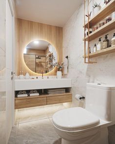 a white toilet sitting next to a bathroom sink under a round mirror in a bathroom