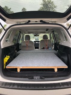 the back end of a van with an open hatchback door and two seats in it