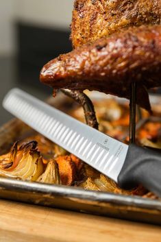 the meat is being cooked on the grill with a large spatula next to it