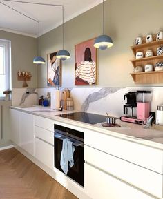 a kitchen with white cabinets and wooden floors