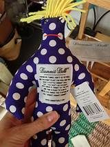 a person holding up a purple and white polka dot covered bottle with writing on it