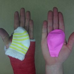 two hands with pink and yellow mitts on their palms, one has a bandage in the palm