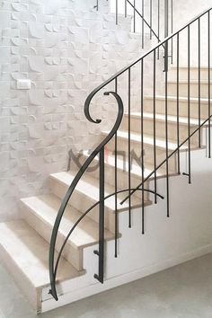 a set of stairs with wrought iron handrails and white painted brick wall in the background