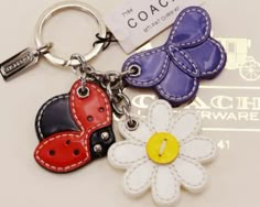 three leather keychains with flowers and ladybugs on them, one has a name tag attached to it