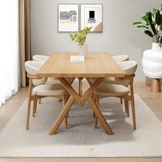 a wooden table with white chairs and a plant