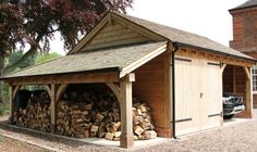 a car is parked in front of a shed with wood stacked up inside and out