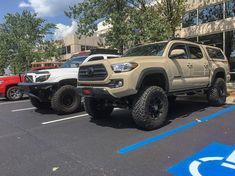 two toyota trucks parked next to each other in a parking lot