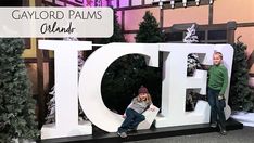 two children are posing in front of the giant ice sign