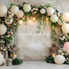 the backdrop is decorated with balloons and greenery as well as flowers, candles and lanterns