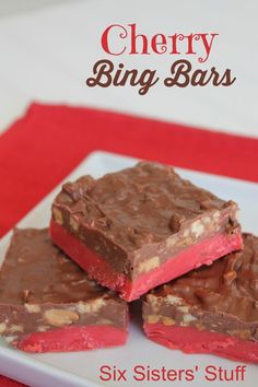 four pieces of chocolate fudge candy on a white plate with red and gold trim