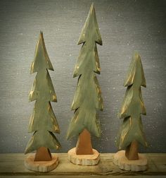 three wooden christmas trees sitting on top of a table