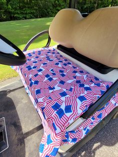 a golf cart seat with an american flag design on the back and tan leather armrests