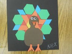 a turkey made out of construction paper sitting on top of a wooden table